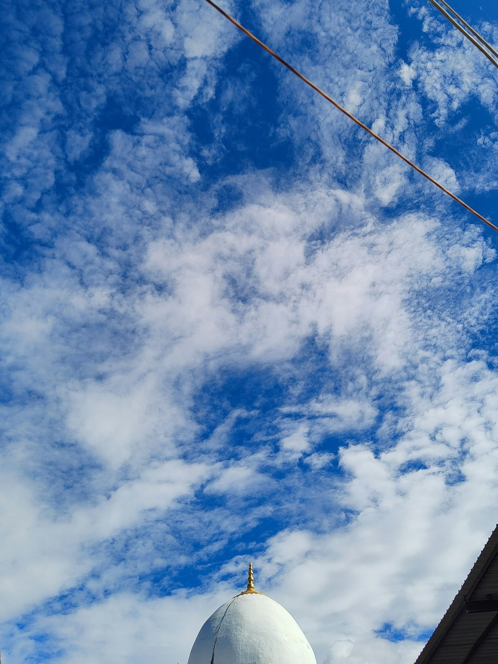 a large white dome sitting under a blue cloudy sky